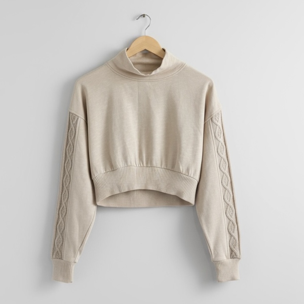Urban Outfitters  cropped sweatshirt with cable-knit detailing on the sleeves.